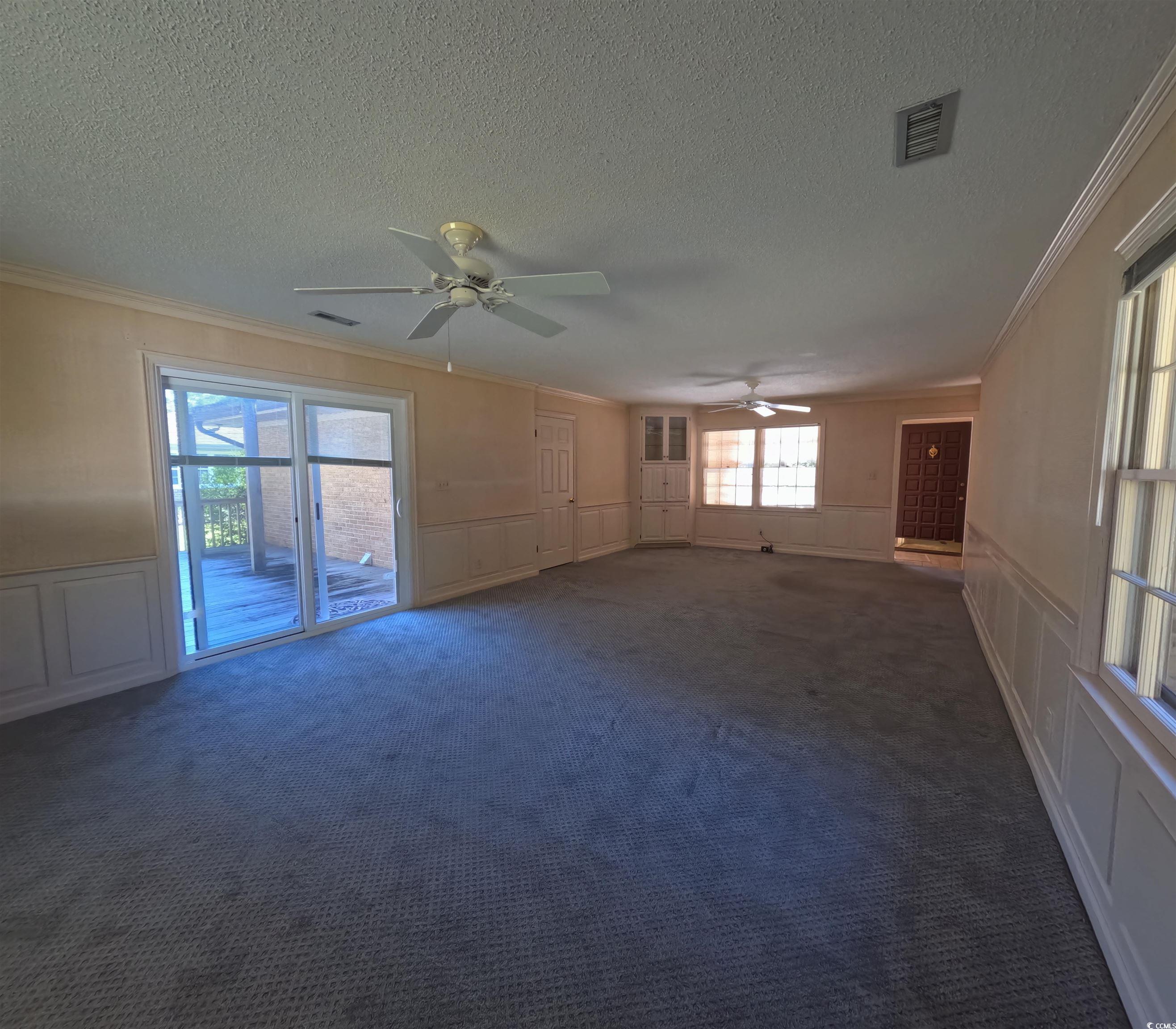 5580 Green Bay Circle Myrtle Beach, SC 29588 - Photo 35 of 36 Unfurnished living room featuring a decorative wall, a wainscoted wall, ceiling fan, and carpet floors
