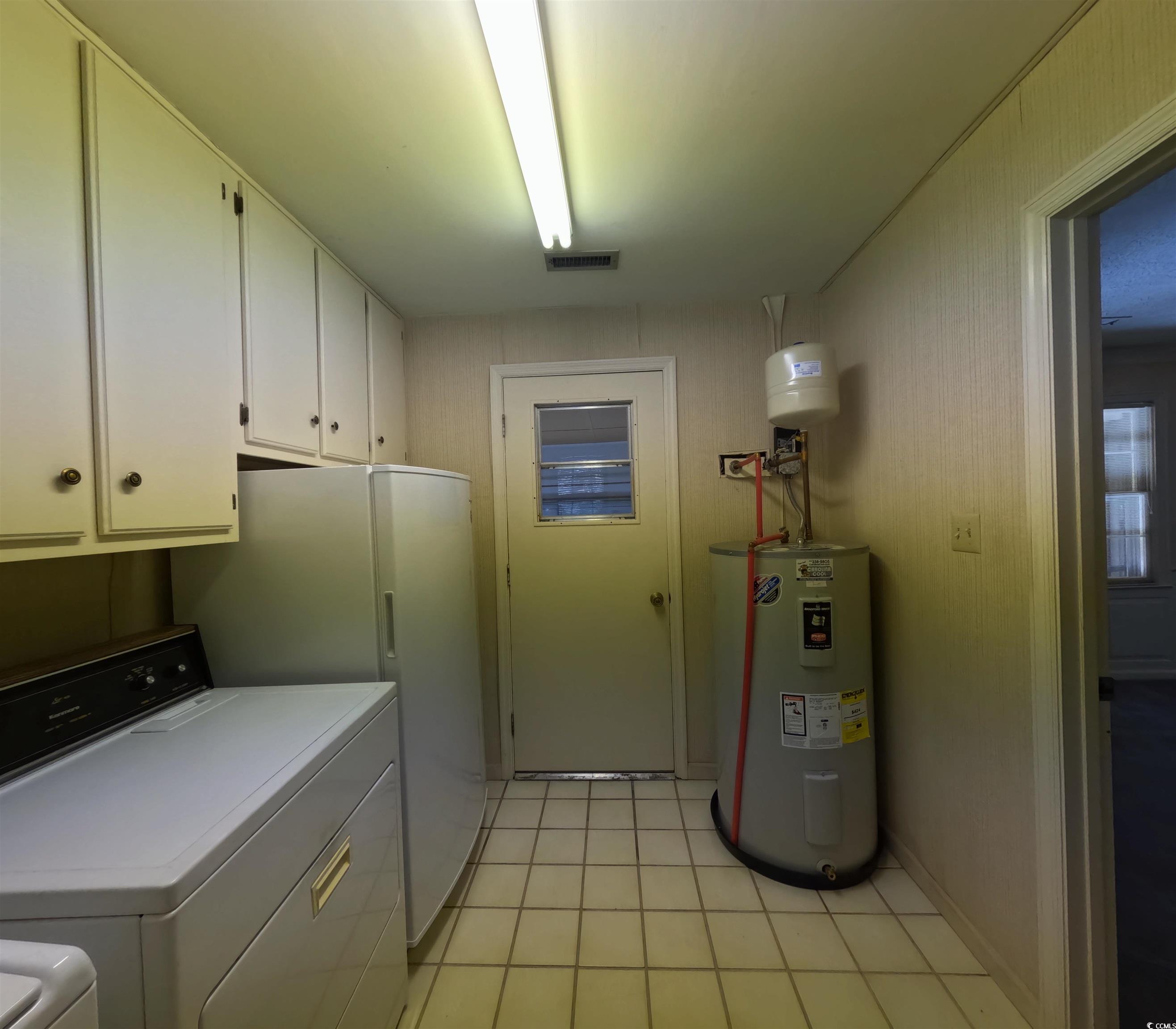 5580 Green Bay Circle Myrtle Beach, SC 29588 - Photo 37 of 37 Washroom with electric water heater, washing machine and dryer, light tile patterned floors, and cabinet space