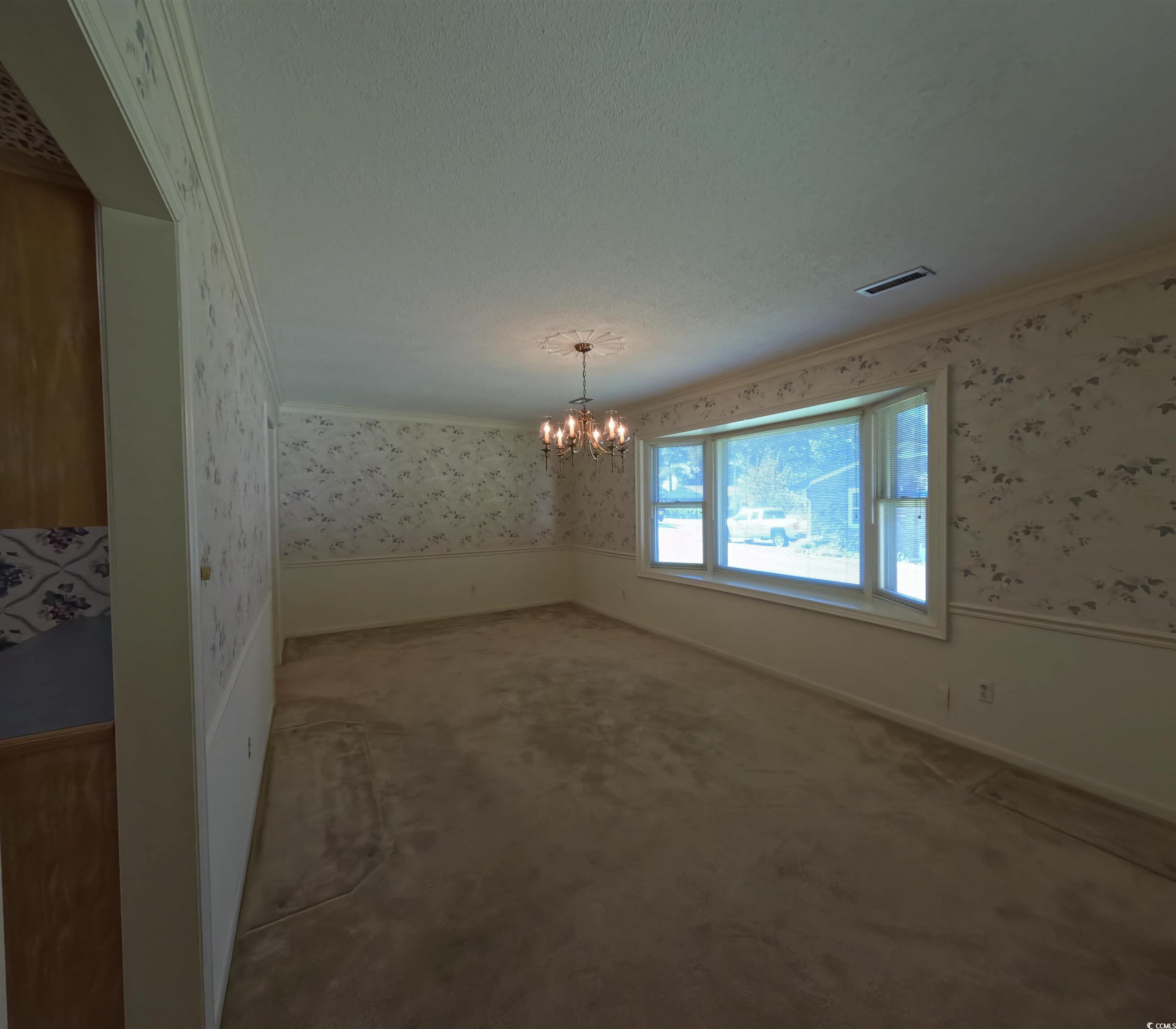 5580 Green Bay Circle Myrtle Beach, SC 29588 - Photo 5 of 36 Unfurnished dining area with wallpapered walls, a chandelier, ornamental molding, a wainscoted wall, and carpet
