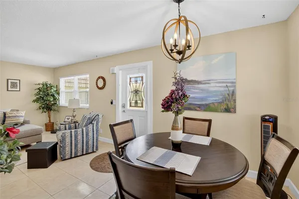 a kitchen with granite countertop stainless steel appliances a dining table chairs stove refrigerator and cabinets