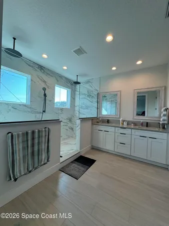 a kitchen with white cabinets a sink dishwasher and a stove with wooden floor