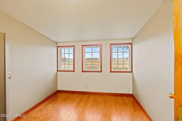 a view of a room with a window and wooden floor