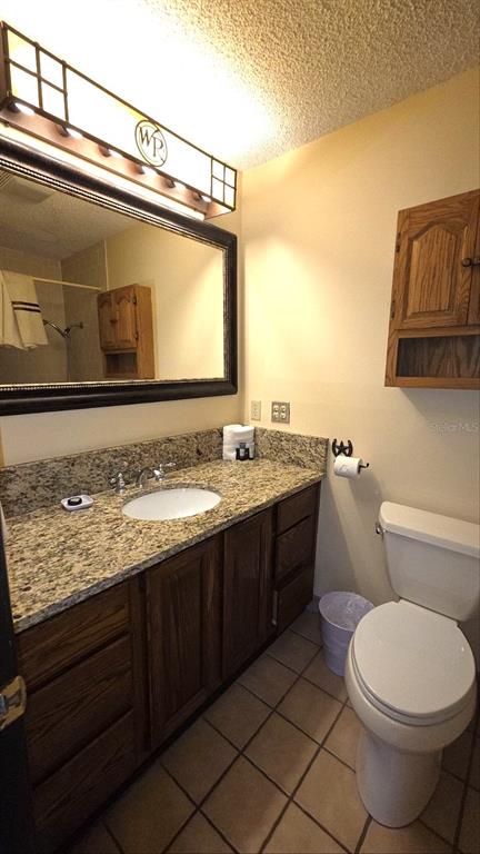 454 Cottage Circle, Unit 454 River Ranch, FL 33867 - Photo 19 of 27 a bathroom with a granite countertop toilet sink and mirror