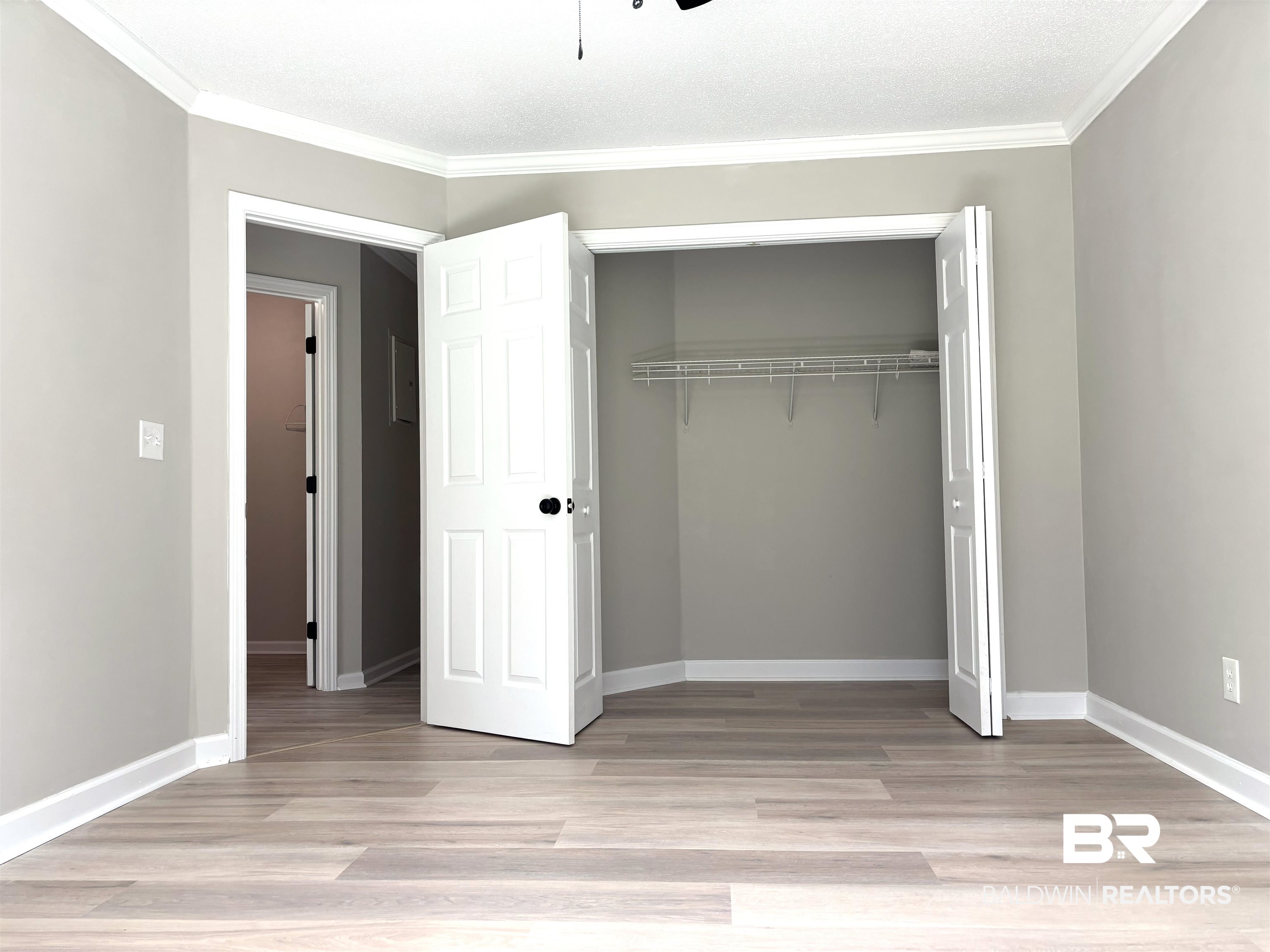 35650 Spring Road North Stapleton, AL 36578 - Photo 44 of 70 Unfurnished bedroom featuring light wood-type flooring, crown molding, and a closet