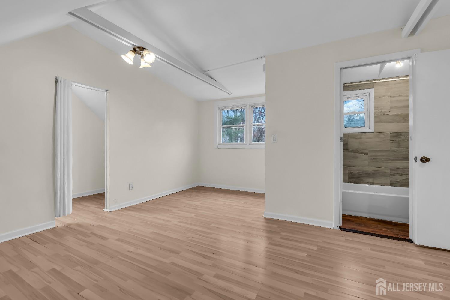 1550 Englishtown Road Old Bridge, NJ 08857 - Photo 12 of 20 a view of an empty room with wooden floor and a window