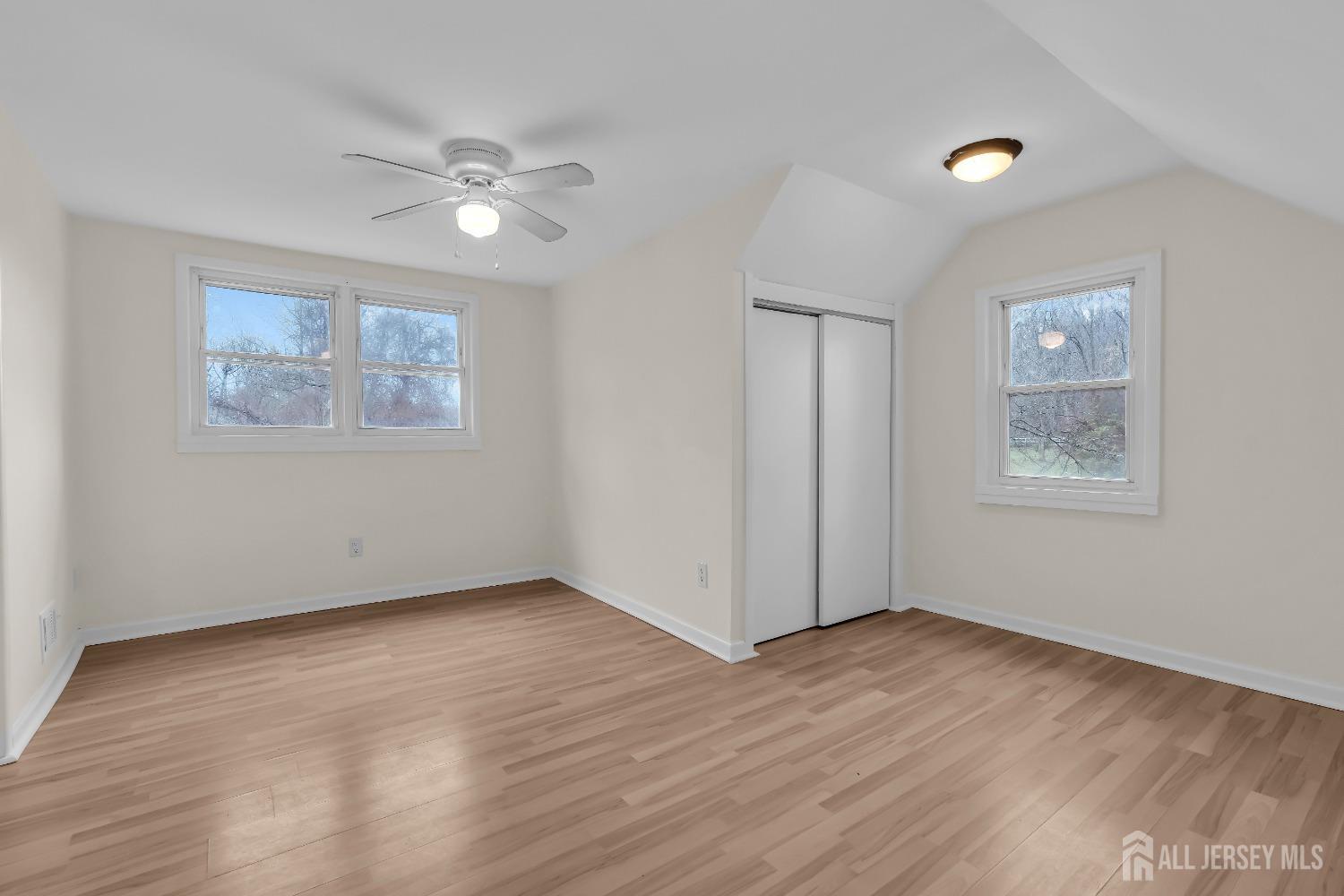 1550 Englishtown Road Old Bridge, NJ 08857 - Photo 14 of 20 a view of an empty room with wooden floor and a ceiling fan