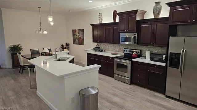 a kitchen with stainless steel appliances a stove refrigerator sink and microwave