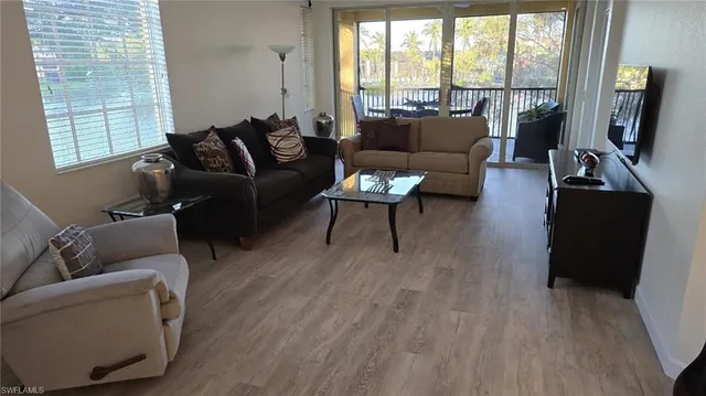a living room with furniture and a flat screen tv with wooden floor