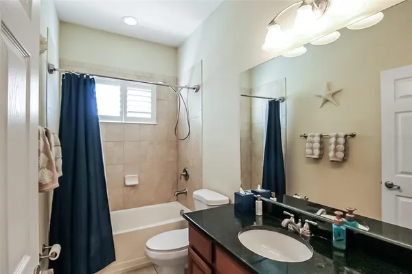 a bathroom with a double vanity sink toilet mirror and shower