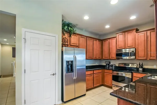 a kitchen with stainless steel appliances granite countertop a stove a sink and a refrigerator with wooden floor