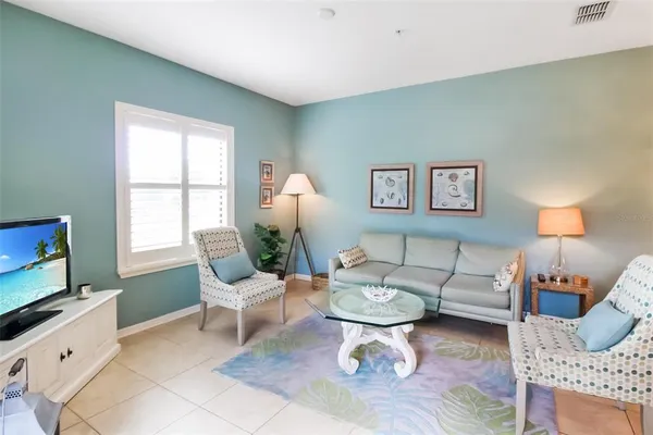 a living room with furniture a flat screen tv and a window
