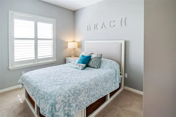 a large bed sitting in a bedroom next to a window