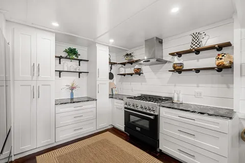 a kitchen with a stove and white cabinets