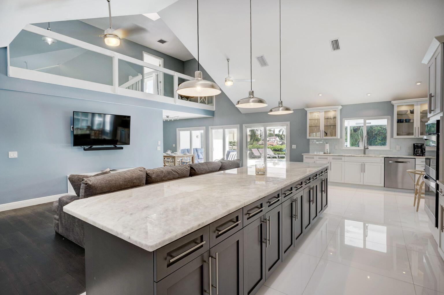 141 Pine Hill Trail West Tequesta, FL 33469 - Photo 20 of 53 a kitchen with stainless steel appliances granite countertop a kitchen island a stove a table and chairs