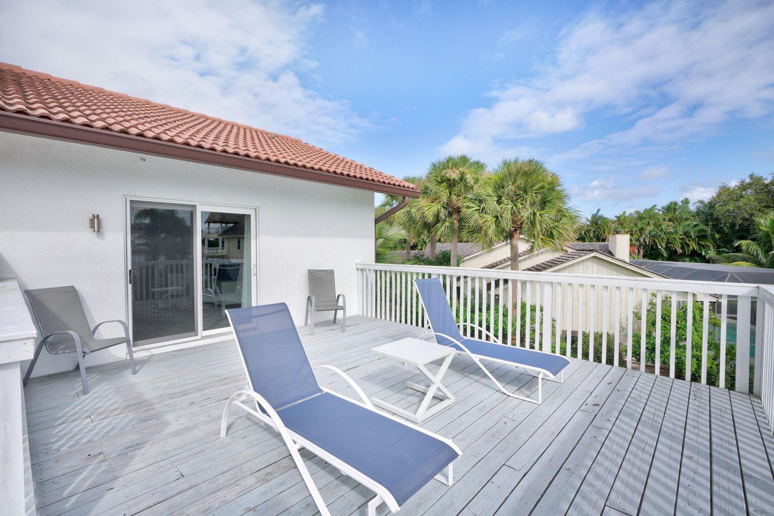 141 Pine Hill Trail West Tequesta, FL 33469 - Photo 45 of 53 a view of a chair and table on the wooden deck