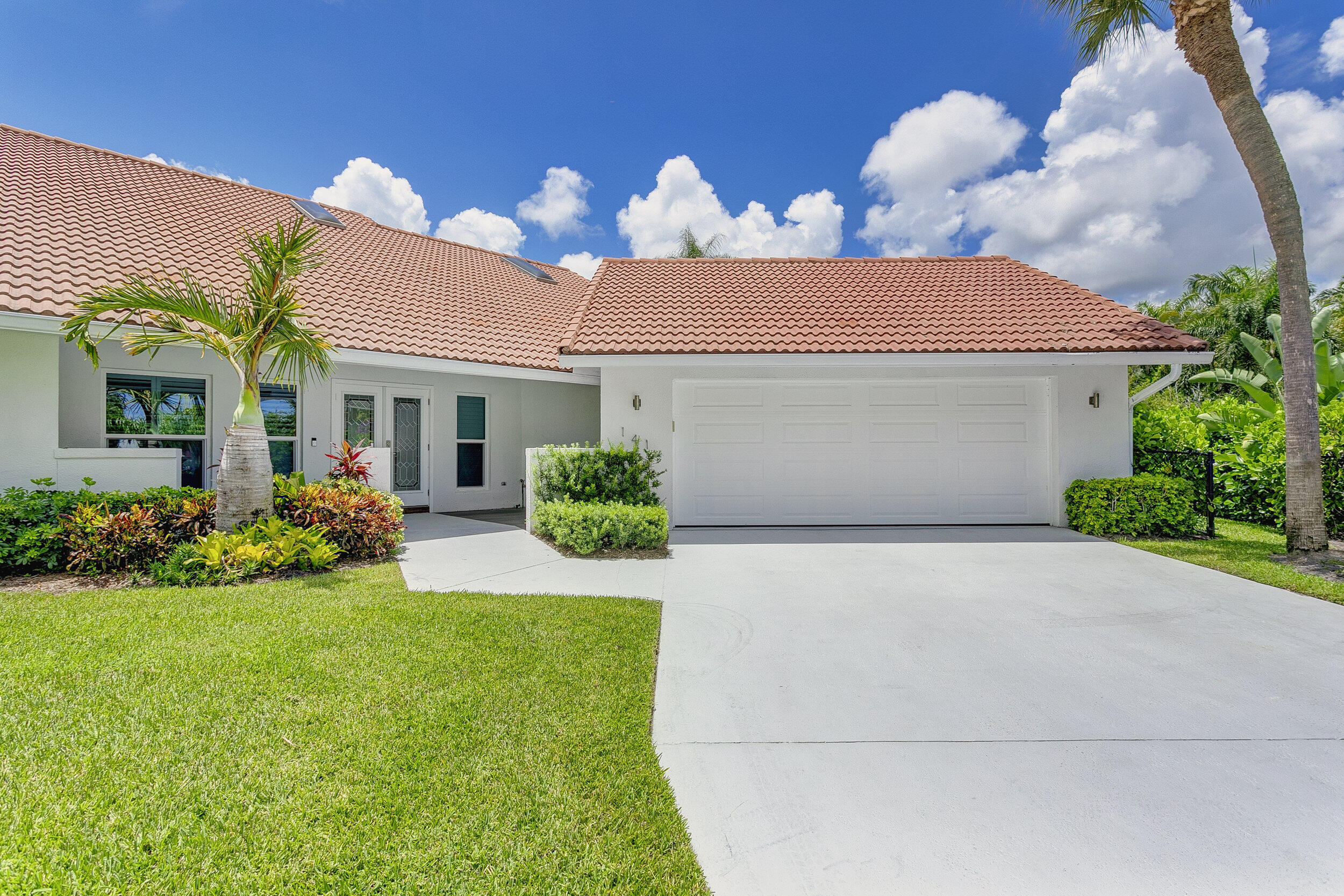 141 Pine Hill Trail West Tequesta, FL 33469 - Photo 50 of 53 a front view of house with yard and outdoor seating