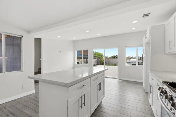 a kitchen with counter top space and wooden floor