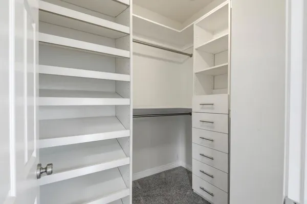 a view of walk in closet with empty racks