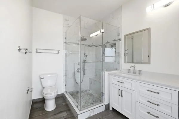 a bathroom with a shower sink mirror and toilet