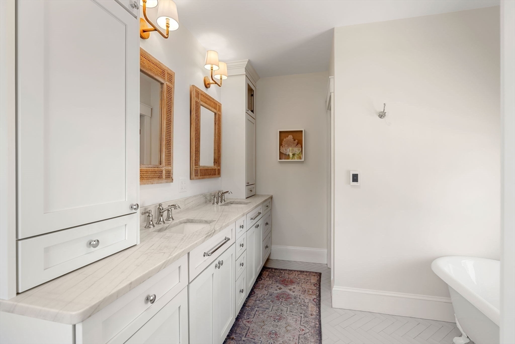 79 Lothrop Street Beverly, MA 01915 - Photo 28 of 42 a bathroom with a double vanity sink a mirror and a bathtub