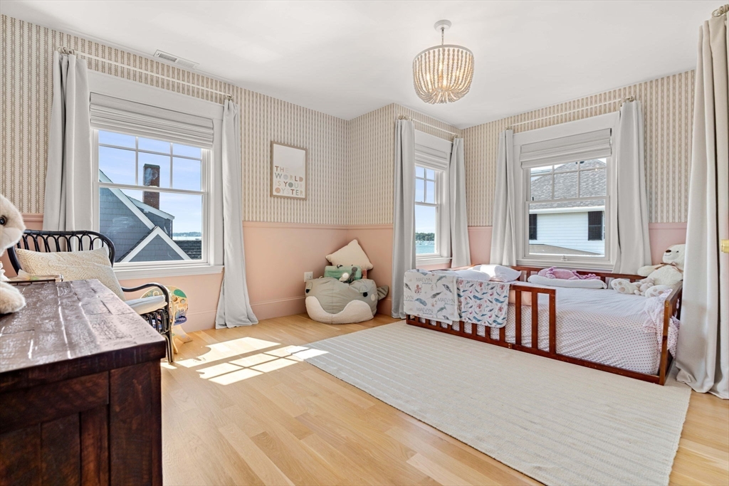 79 Lothrop Street Beverly, MA 01915 - Photo 33 of 42 a bedroom with furniture and a chandelier