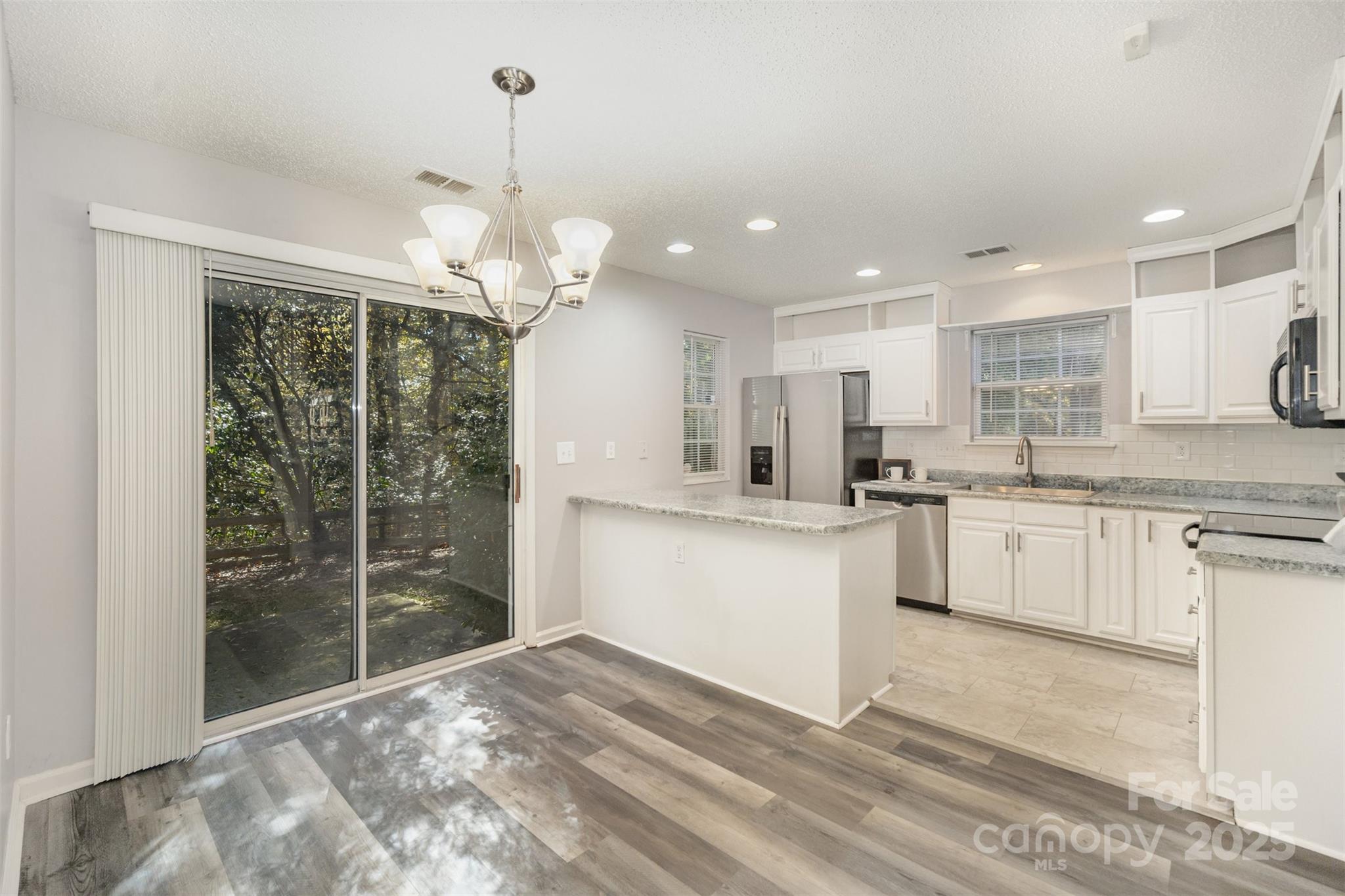 8230 Rudolph Road Charlotte, NC 28216 - Photo 18 of 38 a kitchen with white cabinets and white appliances
