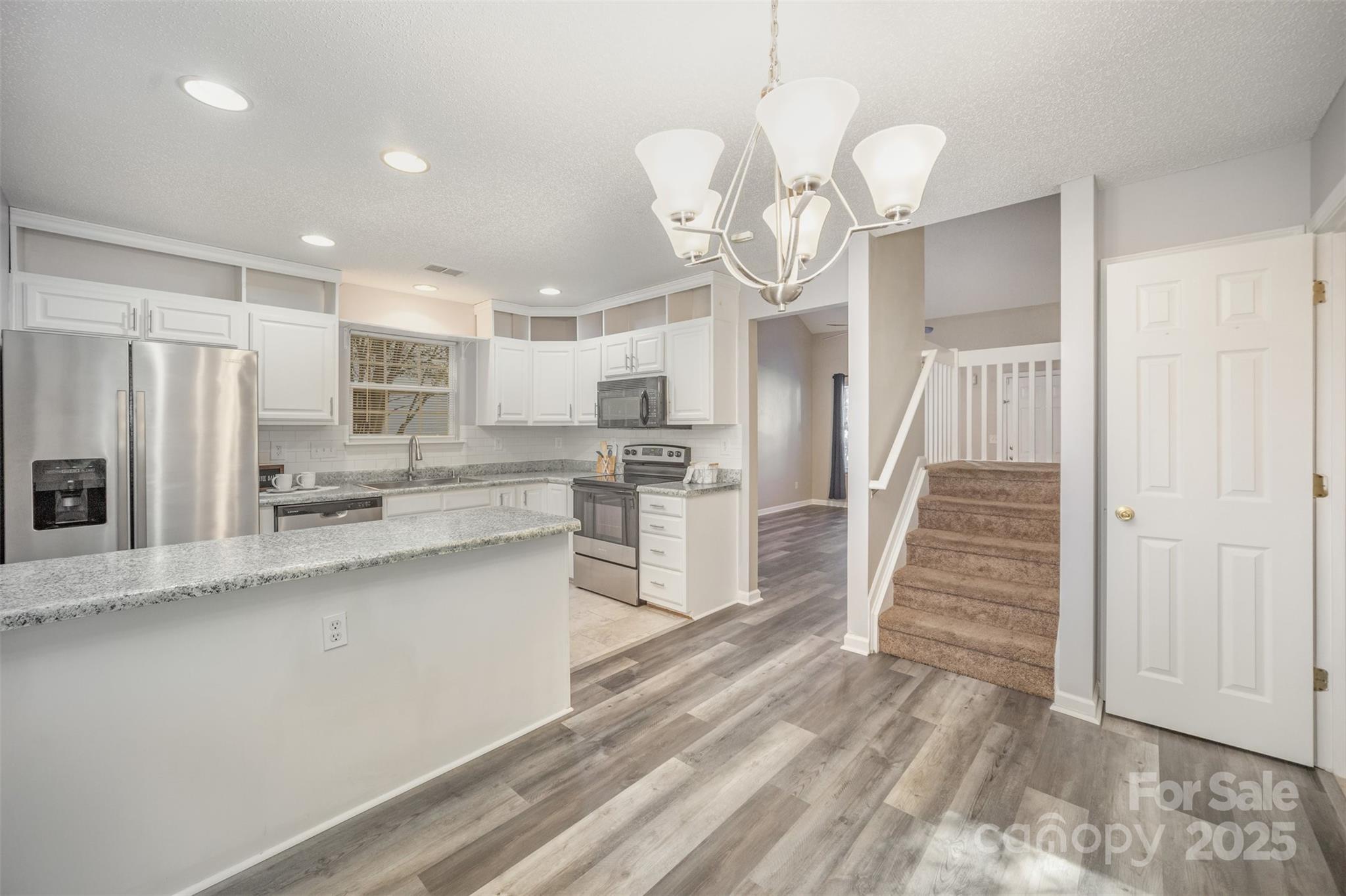 8230 Rudolph Road Charlotte, NC 28216 - Photo 19 of 38 a kitchen with wooden floor and stainless steel appliances