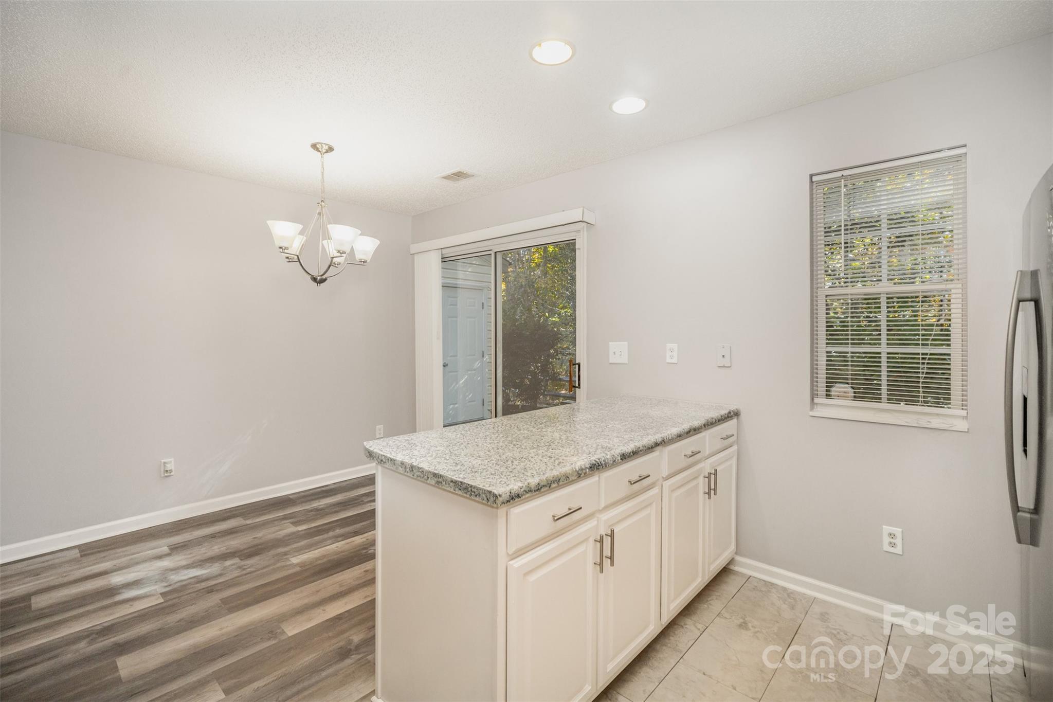 8230 Rudolph Road Charlotte, NC 28216 - Photo 20 of 38 a view with granite countertop kitchen island with a sink and chandelier