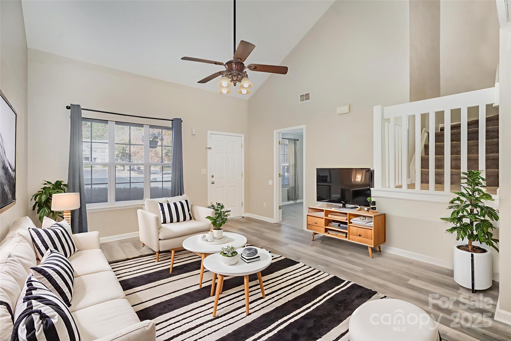 8230 Rudolph Road Charlotte, NC 28216 - Photo 2 of 38 a living room with furniture a flat screen tv and a potted plant