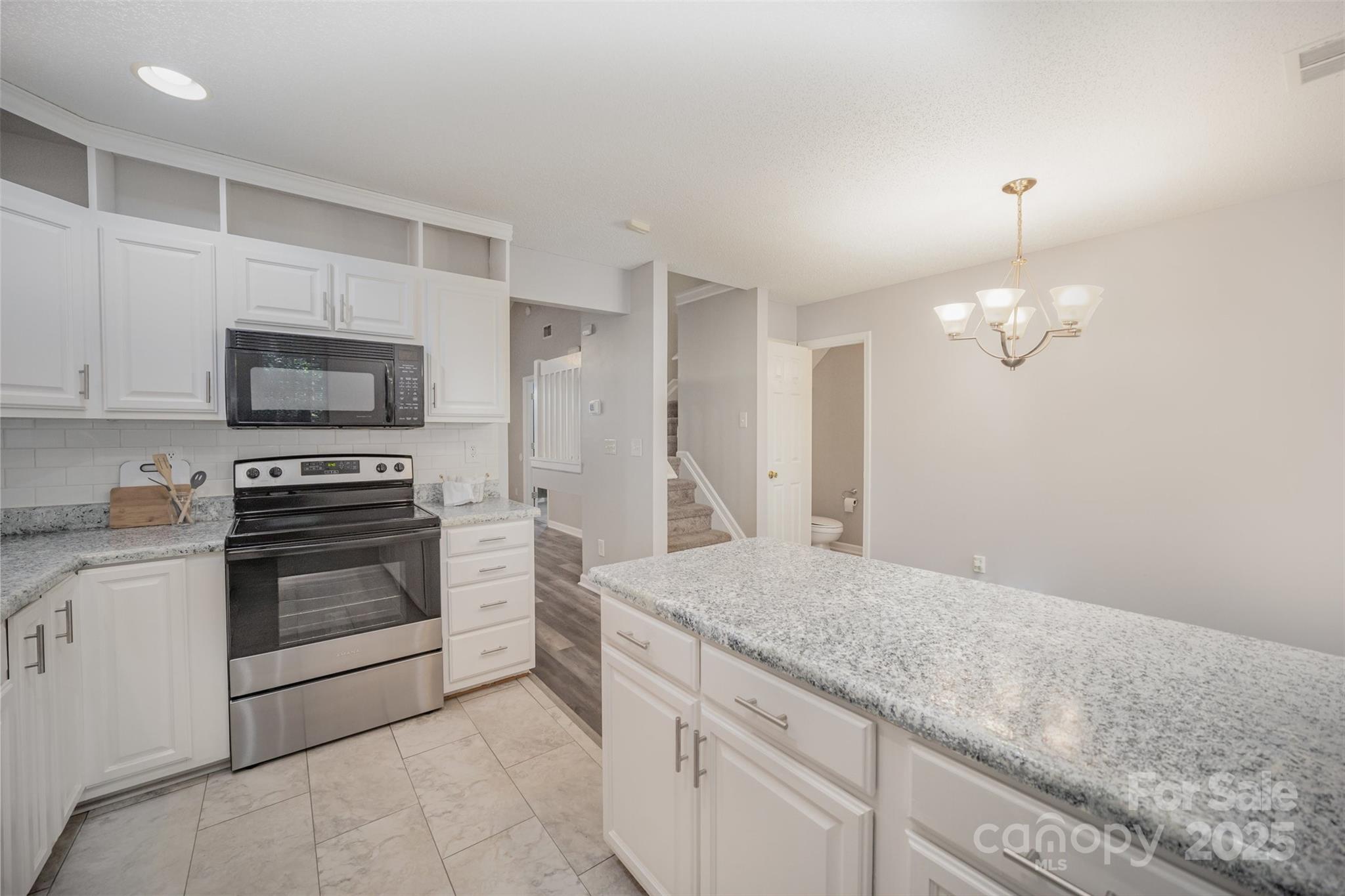 8230 Rudolph Road Charlotte, NC 28216 - Photo 21 of 38 a kitchen with granite countertop a stove a sink and a microwave