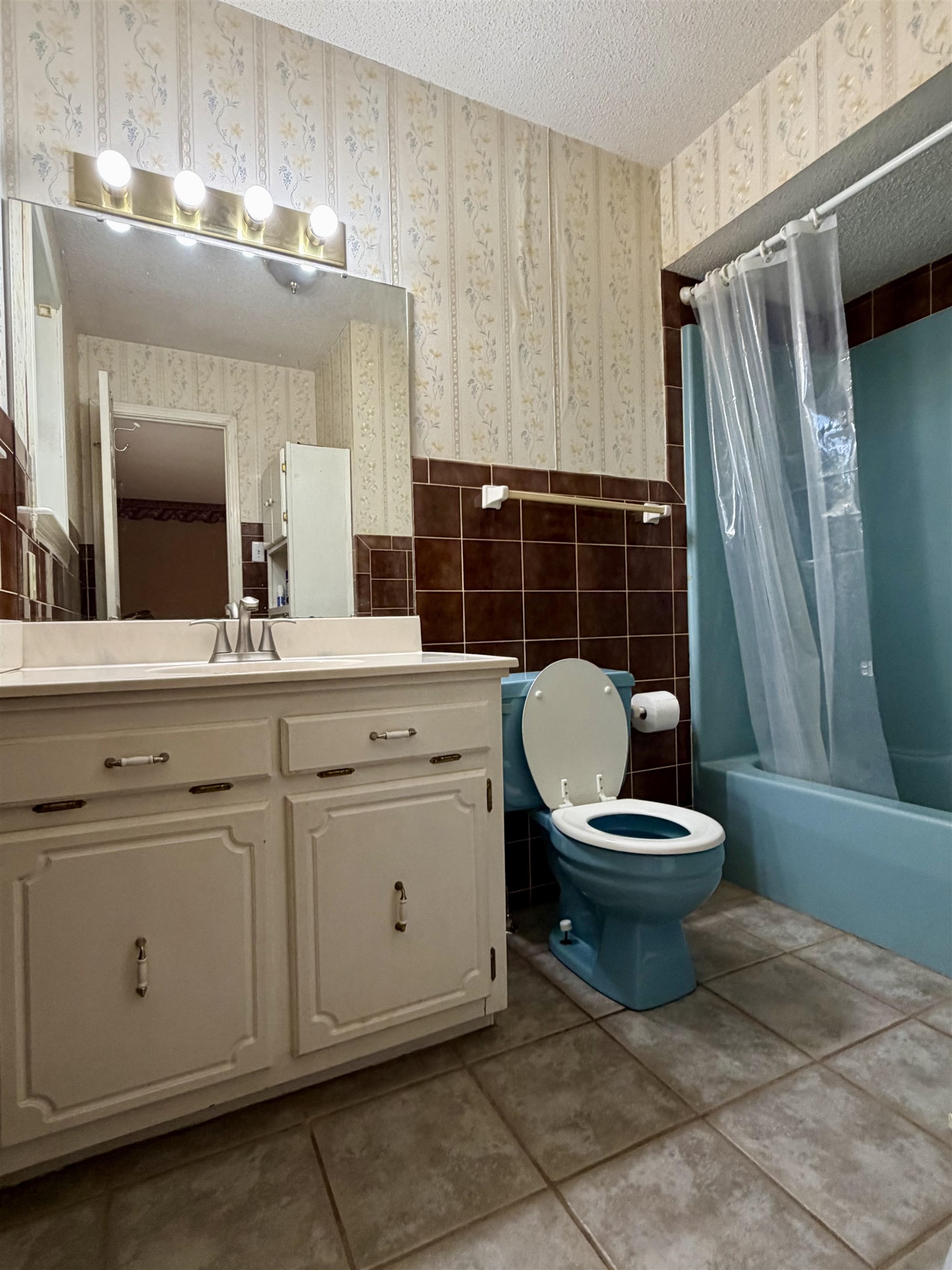 373 Clarence Barham Road Bethel Springs, TN 38315 - Photo 15 of 28 Bathroom featuring a vanity with integrated sink, a built-in mirror, overhead vanity lighting, a full-size bathtub, and tile flooring