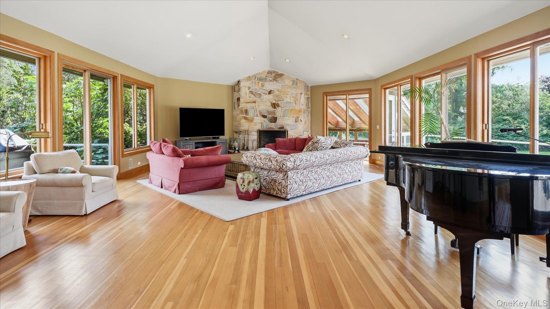 25 Ring Neck Road Remsenburg, NY 11960 - Photo 15 of 19 Expansive, sunlit great room with stone fireplace and exit to personal greenhouse.