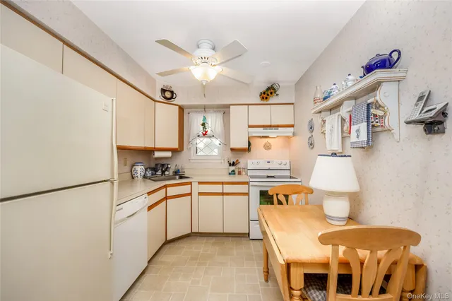 a kitchen with stainless steel appliances a sink a stove a refrigerator and white cabinets