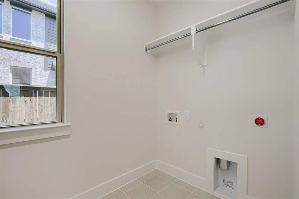 824 Stone Grv Road Lavon, TX 75166 - Photo 17 of 26 Laundry space featuring light beige tile flooring, a window with a brown frame, and a built-in hanging rod