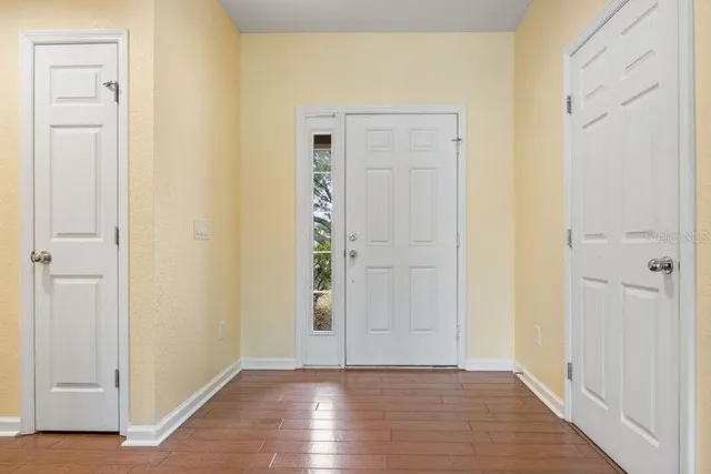 an empty room with wooden floor & closet area