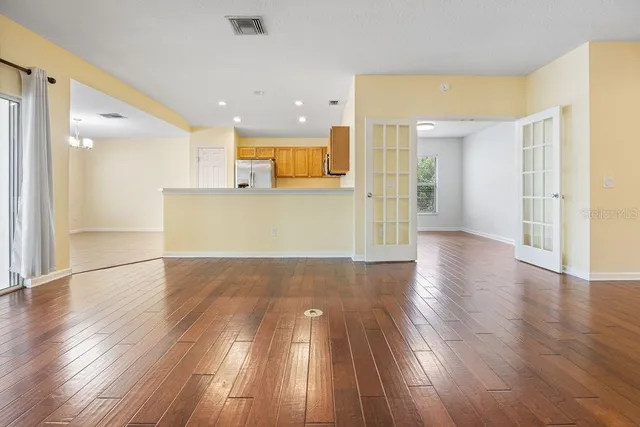a view of a big room with wooden floor and windows