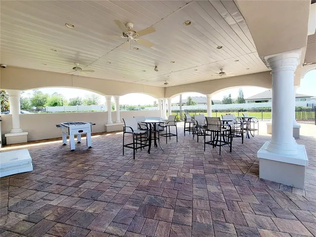 a outdoor space with lots of tables a large window and chairs