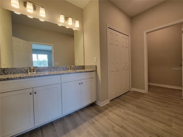 a bathroom with a granite countertop sink and a mirror