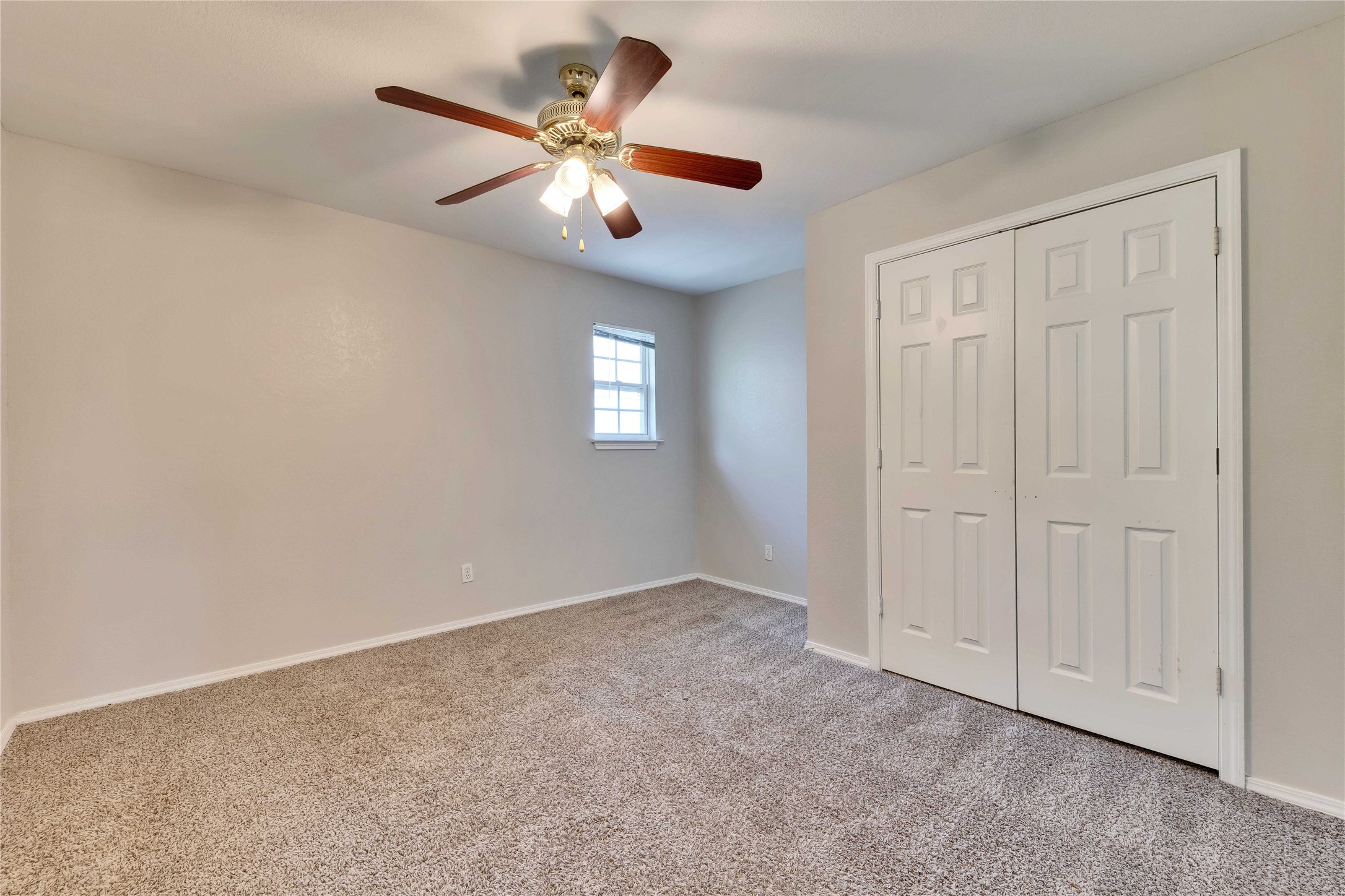 2201 East 18th Street, Unit B Austin, TX 78702 - Photo 13 of 25 A well-lit bedroom features plush carpeting and a convenient closet with bi-fold doors.
