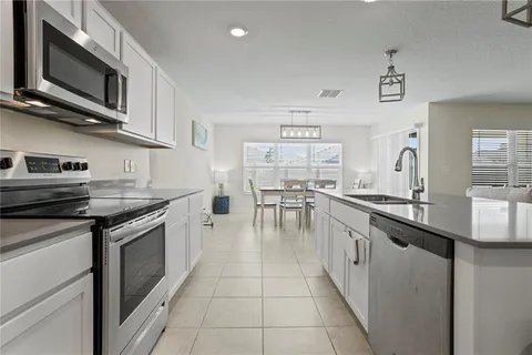 a kitchen with stainless steel appliances granite countertop a stove top oven a sink a counter space and cabinets