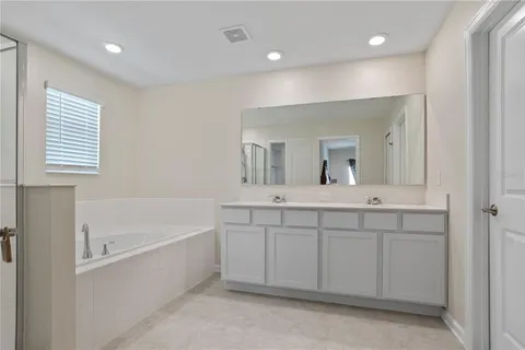 a bathroom with a tub sink and mirror