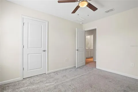 an empty room with a window and a fan