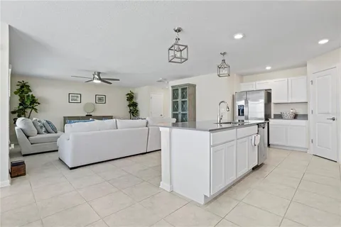 a living room with kitchen island furniture and ceiling fan
