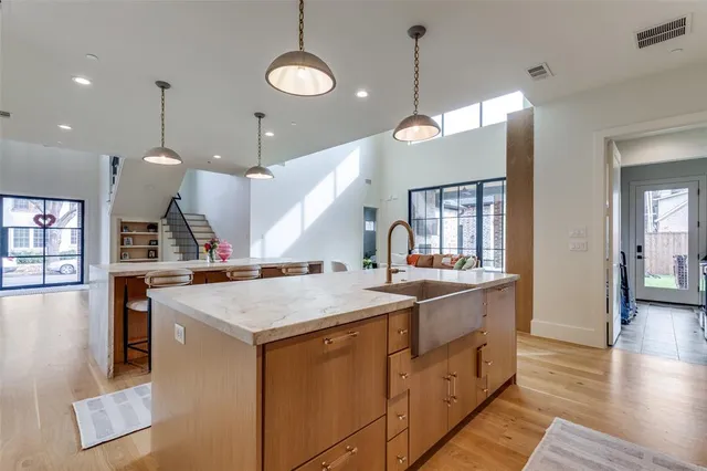 a kitchen with a stove a sink a center island and wooden floor