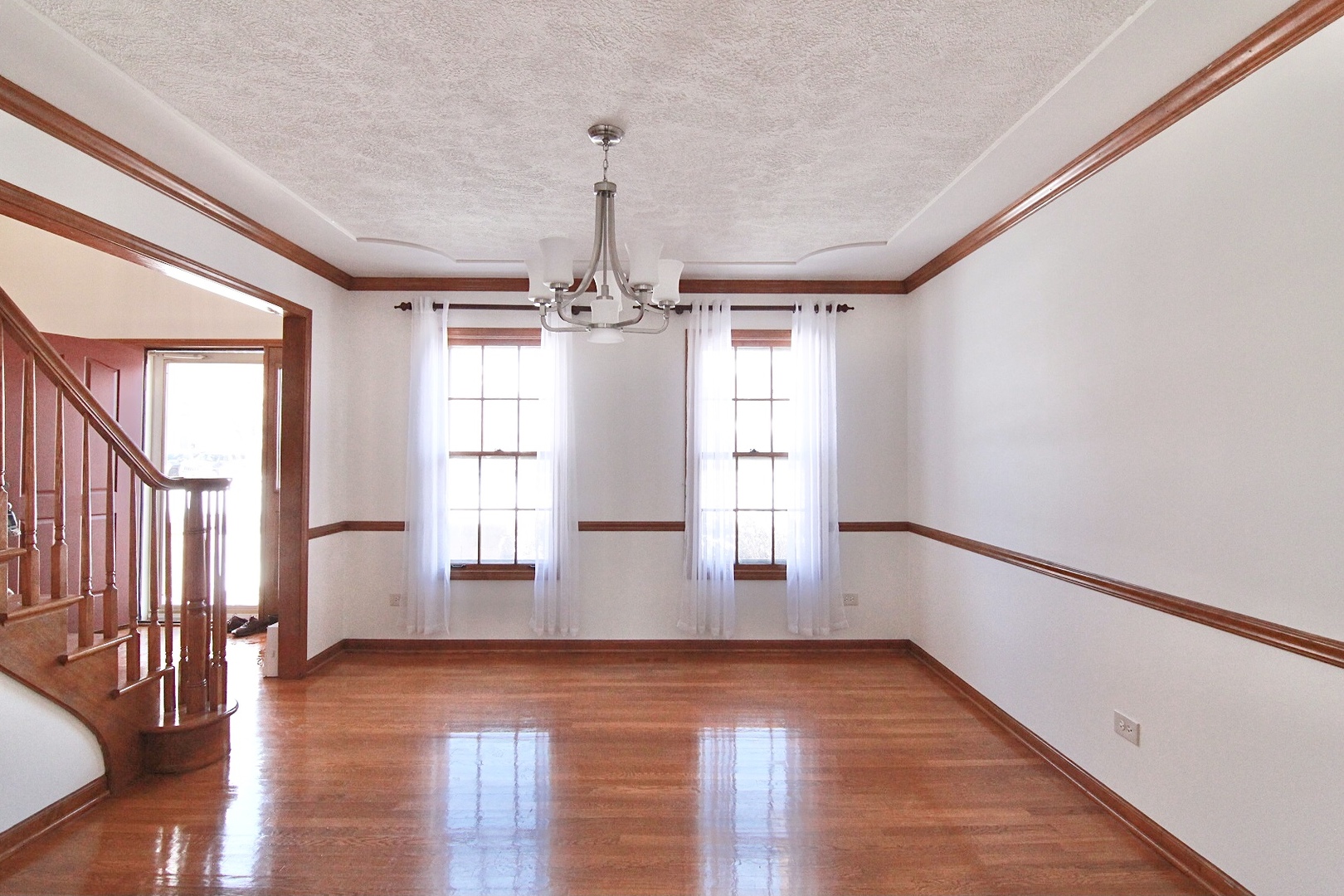 2457 Barkdoll Road Naperville, IL 60565 - Photo 4 of 27 a view of an empty room with wooden floor and a window