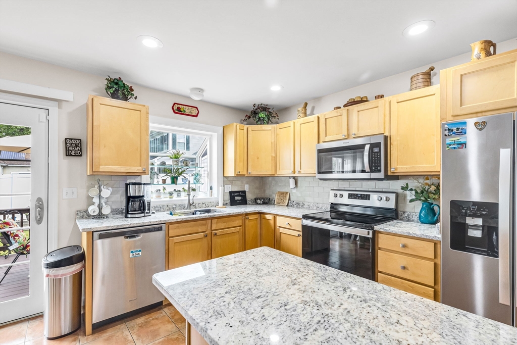 297 Christopher Drive Springfield, MA 01119 - Photo 9 of 30 a kitchen with stainless steel appliances granite countertop a sink stove refrigerator and cabinets