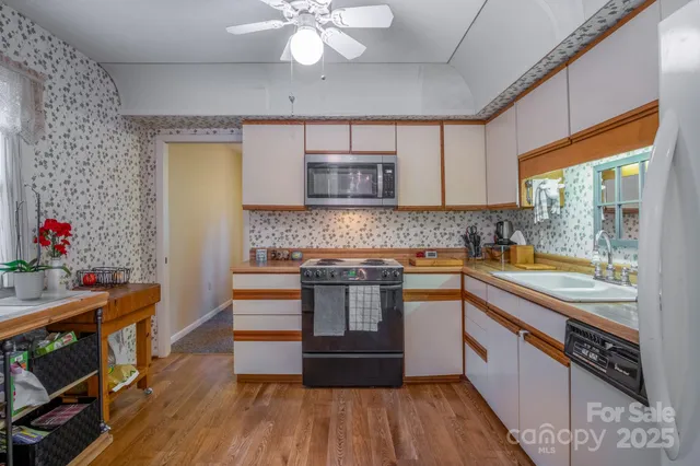 a kitchen with stainless steel appliances granite countertop a sink and wooden cabinets