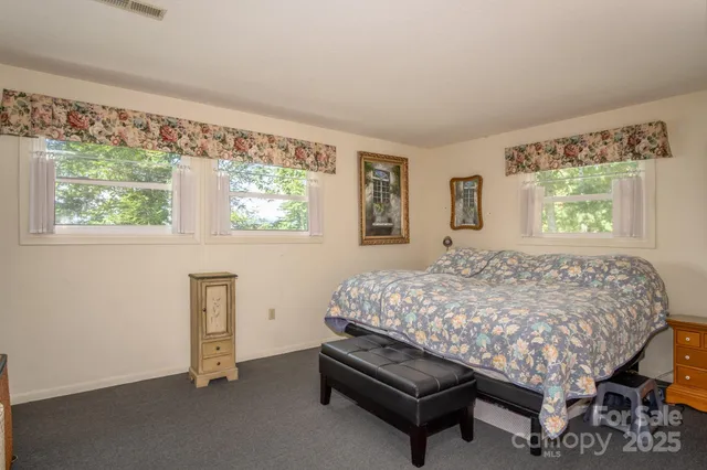 a bed sitting in a bedroom next to a window