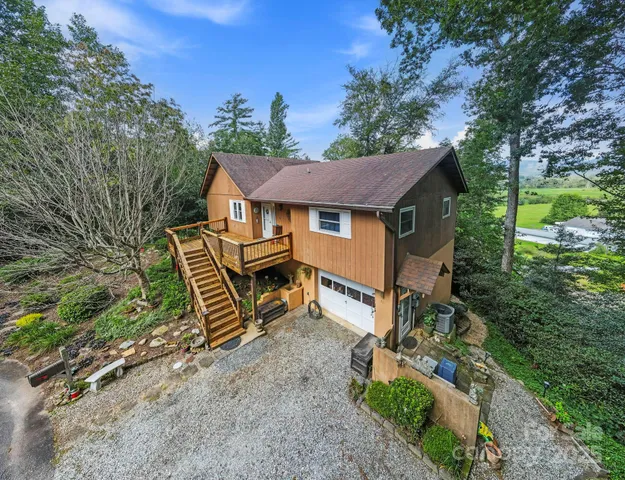 a view of a house with a yard and hanging chair