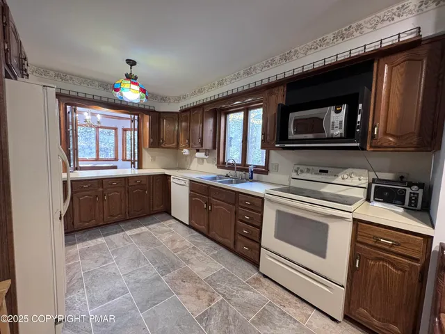 a bathroom with a granite countertop sink a toilet a mirror and shower